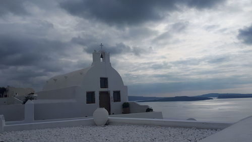 Building by sea against sky