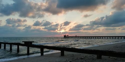 Pier over sea against sky during sunset