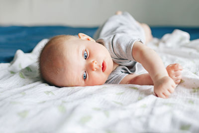 Portrait of cute baby lying on bed