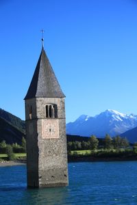 Church by building against blue sky