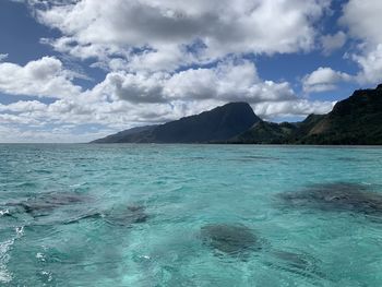 Scenic view of sea and mountains against sky