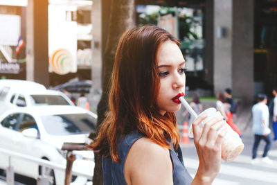 Portrait of woman drinking water from car