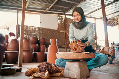 Portrait of young woman sitting in workshop