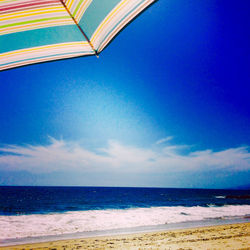 Scenic view of beach against blue sky