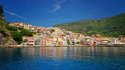 Houses by sea against sky in town