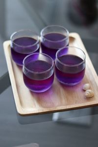 High angle view of purple drink in glasses on table