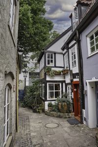 Street amidst houses against sky