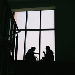 Low angle view of silhouette people in window