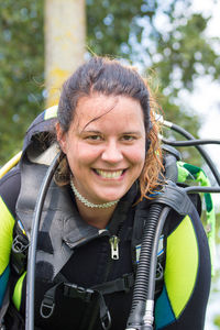 Close-up portrait of happy woman in diving suit with aqualung