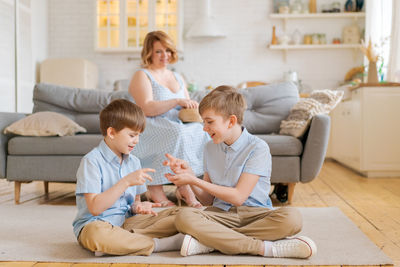 Family using digital tablet while sitting on sofa at home