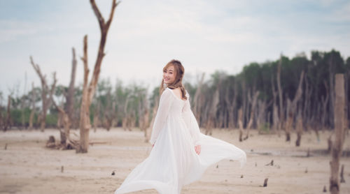 Portrait of young woman standing at beach