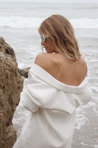 Portrait of young woman standing at beach