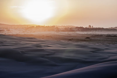 Scenic view of land against sky during sunset