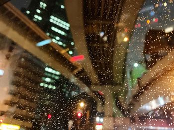 City street seen through wet glass window at night