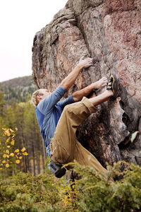 Side view of man rock climbing