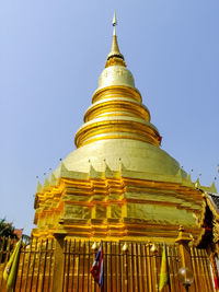 Low angle view of statue against temple against clear sky