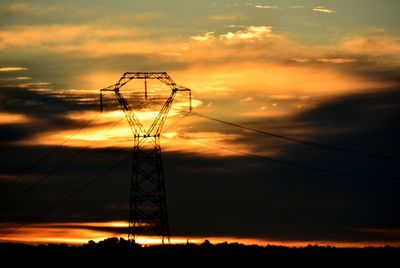 Silhouette electricity pylon against sky during sunset