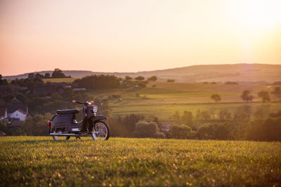 Motorcycle on countryside landscape against clear sky