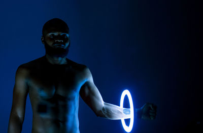 Young man standing against blue background