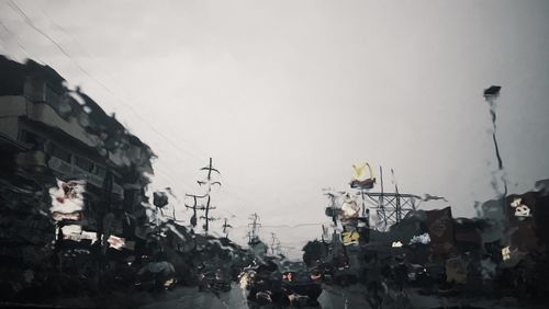Crowd in city against sky