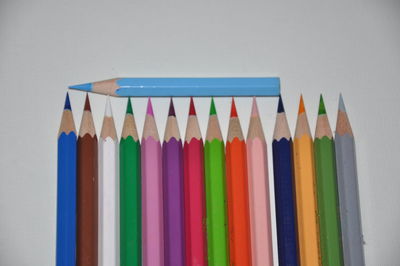 Close-up of multi colored pencils on white table