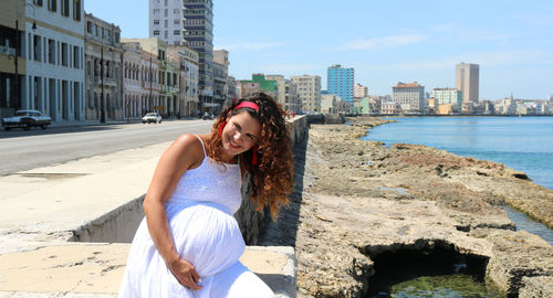 Full length of young woman in city against sky