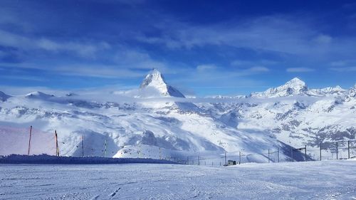 Scenic view of snowcapped mountains against blue sky