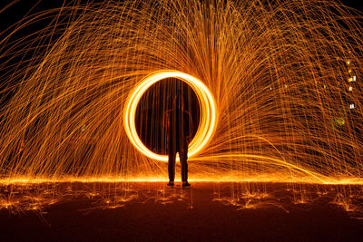 Man spinning wire wool at night