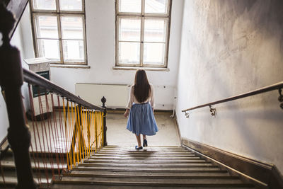 Rear view of woman walking on staircase