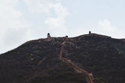 Low angle view of people on mountain against sky