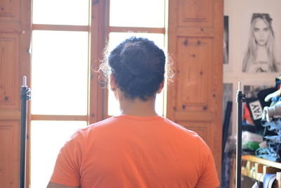 Rear view of man looking at window