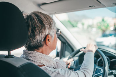 Rear view of woman sitting in car