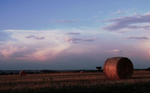 Hay bales on field against sky