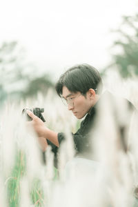 Portrait of man with his camera in the middle of white reeds