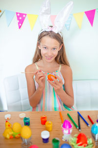 Portrait of girl painting egg