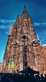 Low angle view of crowd outside building against sky