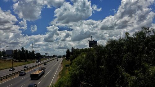 Cars on road in city against sky