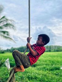 A boy climbing a rope