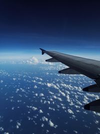 Airplane flying over clouds in blue sky