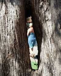 Close-up of woman by tree trunk in cave