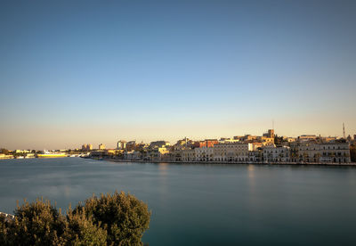 City by river against clear sky