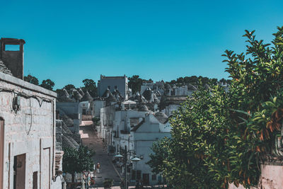 Buildings in city against clear blue sky