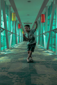 Portrait of happy boy standing in elevated walkway