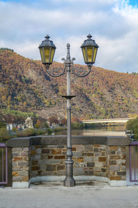 Street light by building against sky
