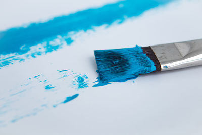 High angle view of blue paint on table