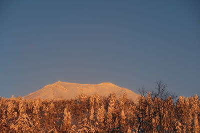 Scenic view of mountains against clear sky during winter