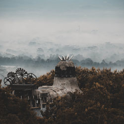 Built structure with trees and fog in background