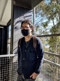 Portrait of young man wearing sunglasses standing outdoors