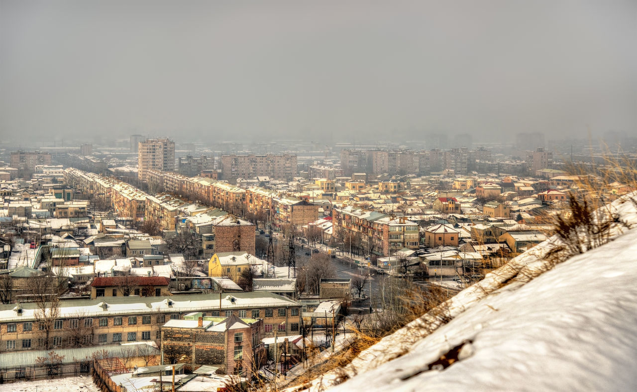 HIGH ANGLE VIEW OF BUILDINGS IN CITY AGAINST SKY