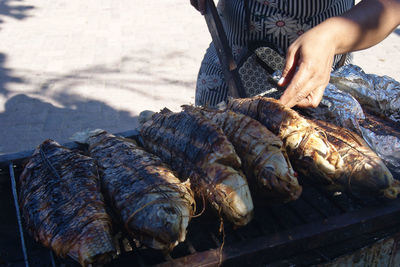 Pescado asado. woman preparing fresh fish on the grill.